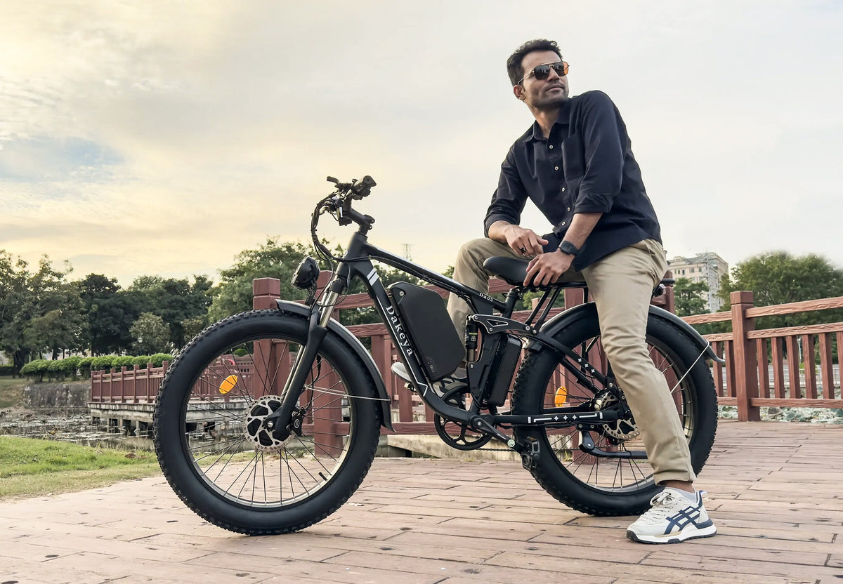 Person seated on a black fat-tire electric bike beside a wooden railing