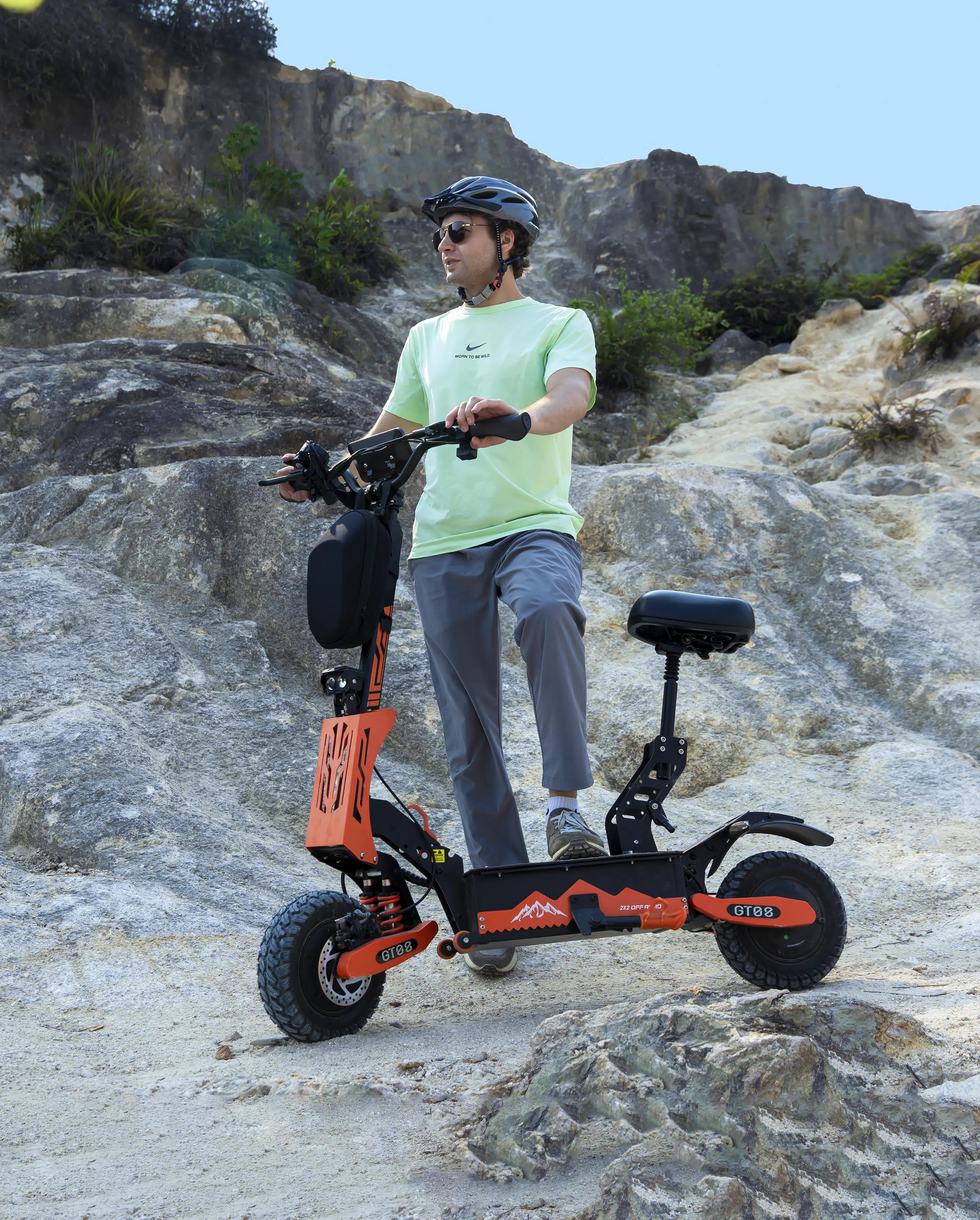 Rider with GT08 off-road electric scooter on rocky mountain terrain